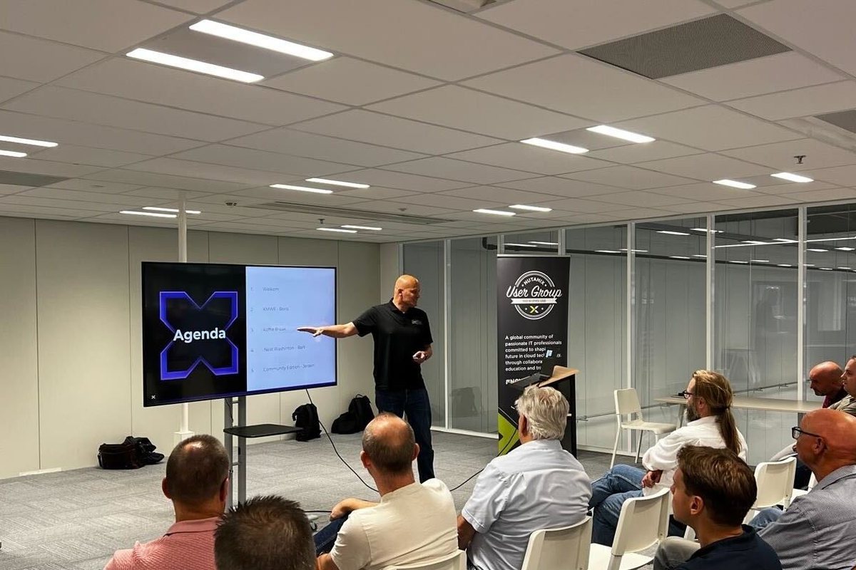 Jeroen pointing at the agenda on a screen while opening a meeting of the Nutanix User Group Netherlands